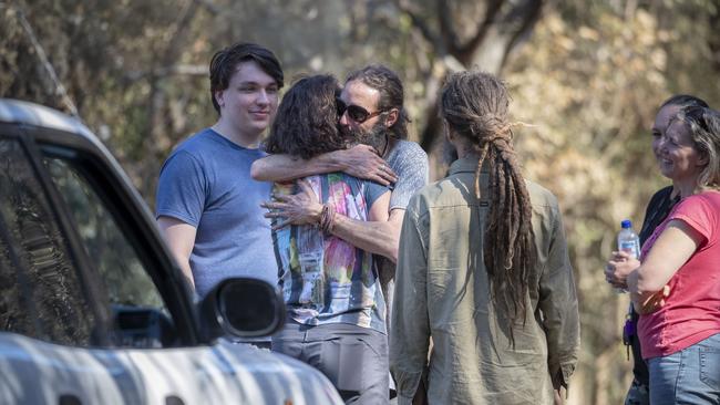 Locals comfort each other as the enormity of the Beechmont bushfire disaster hits.