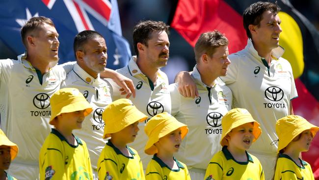 BRISBANE, AUSTRALIA - JANUARY 25: The Australian players embrace for the national anthem during day one of the Second Test match in the series between Australia and West Indies at The Gabba on January 25, 2024 in Brisbane, Australia. (Photo by Bradley Kanaris/Getty Images)