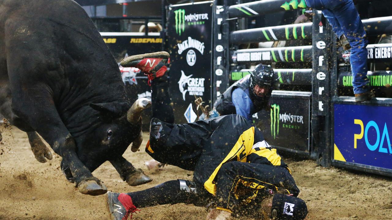 The PBR Cairns Invitational was held at the Cairns Convention Centre on Saturday, June 15. New Zealand bull rider Merv Church falls from Road Rage, who charges protection athlete Geoff Hall and throws him into the air. PICTURE: BRENDAN RADKE