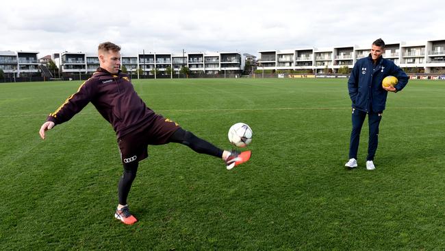 Hawks star Sam Mitchell shows his soccer skills off as Tottenham jet Erik Lamela looks on. Picture: AAP