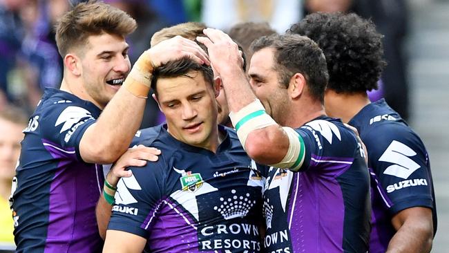 Team-mates congratulate Cooper Cronk (centre)of the Storm after he scores a try, during the round 21 NRL match between the Melbourne Storm and Manly-Warringah Sea Eagles at AAMI park in Melbourne, Sunday, July 30, 2017.(AAP Image/Joe Castro) NO ARCHIVING, EDITORIAL USE ONLY