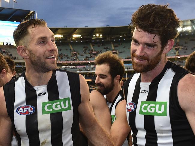 Travis Cloke (left) and Tyson Goldsack of the Magpies make their way from the ground after the Round 23 AFL match between the Hawthorn Hawks and the Collingwood Magpies at the MCG in Melbourne, Sunday, Aug. 28, 2016. (AAP Image/Julian Smith) NO ARCHIVING, EDITORIAL USE ONLY