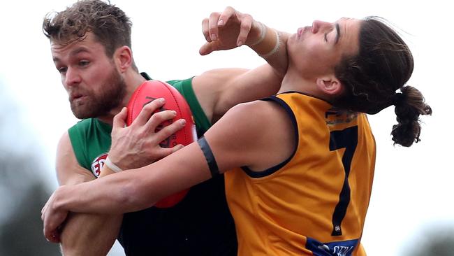 Strathmore’s Benjamin Holian cops a fend off from a Greenvale opponent. Picture: Mark Dadswell