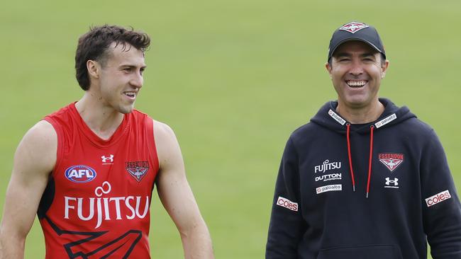 MELBOURNE , AUSTRALIA. February 17 , 2024.  AFL. Essendon training at the Hangar, Tullamarine.  Brad Scott, senior coach of the Bombers shares a laugh with Andrew McGrath  during training today  . Pic: Michael Klein