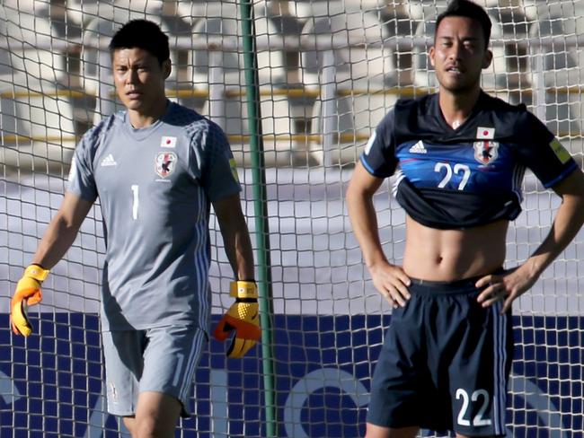 Japan's players react after the Iraqi team scored a goal against them during their 2018 World Cup qualifying football match between Japan and Iraq at the Dastgherdi Stadium in the Iranian capital Tehran on June 13, 2017. / AFP PHOTO / ATTA KENARE