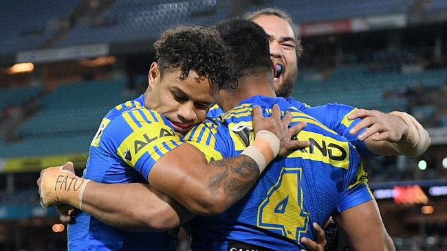 Kirisome Auva’a of the Eels, (centre), celebrates with teammates after scoring a try against the Warriors.