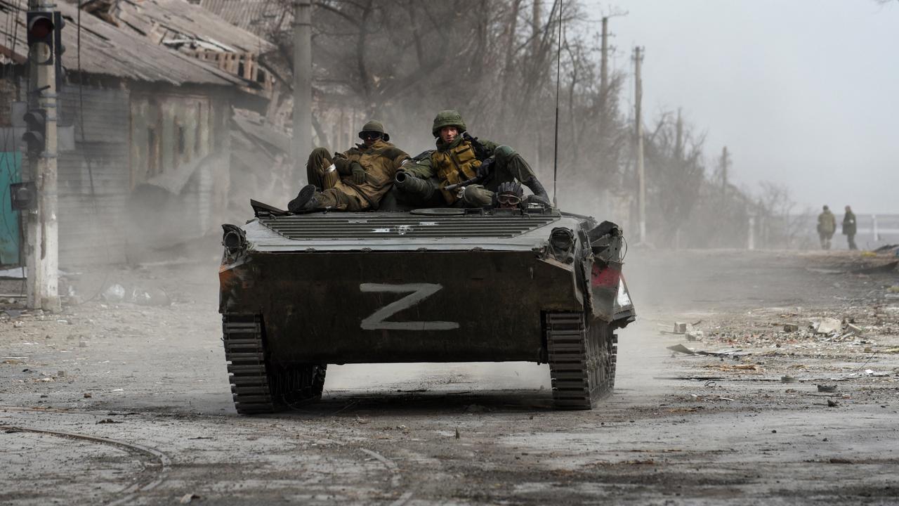 Service members of pro-Russian troops sit atop of an armoured vehicle, which moves along a street in the course of Ukraine-Russia conflict in the southern port city of Mariupol, Ukraine on April 1, 2022. Picture: Reuters