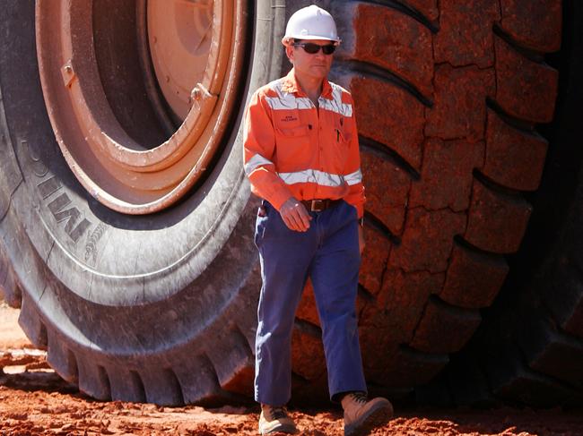 A truck driver is dwarfed by the huge Michelin XDR radial tires of a dump truck used to haul ore from the open pit of Newcrest Mines' Telfer Mine in the Pilbara region of Western Australia Thursday, July 28, 2005. When the mine is fully operational it will be Australia's largest gold and copper producer. Photographer: Will Burgess Bloomberg News