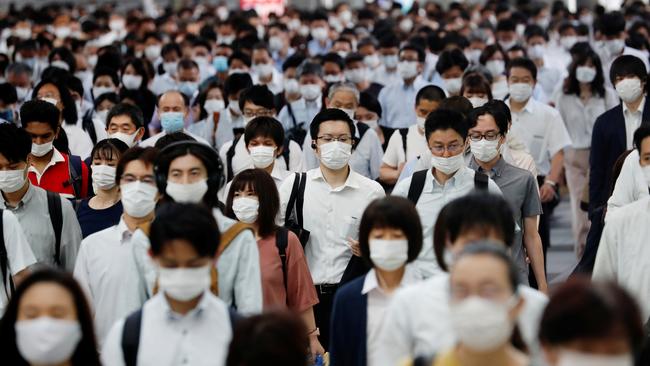 People wearing protective masks amid the coronavirus outbreak make their way during rush hour at a railway station in Tokyo. Picture: Reuters