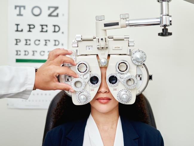 Woman, eye exam and optometrist vision health test for healthy eyecare, eye machine and equipment for testing eyes. Optician, ophthalmologist and clinic for free test for new glasses or contact lense. Picture: Getty Images