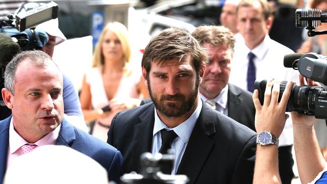 Titans NRL player David Taylor (centre) faces a media scrum at a court appearance with lawyer Campbell MacCallum. Picture: Adam Head