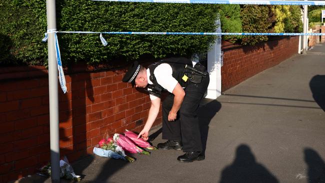 A police officer lays floral tributes in Southport. Picture: AFP.