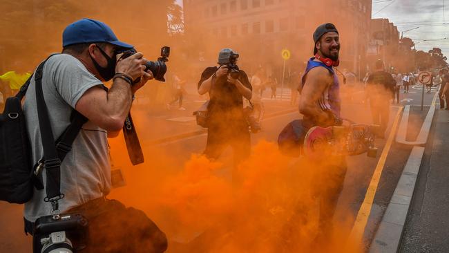 A protester among smoke from flares. Picture: Jake Nowakowski