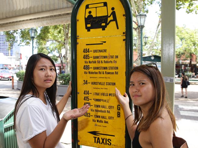 Bus signs in Strathfeild Square are hopelessly out of date, confusing commuters. (L-R) Suki Fan (Strathfield) and Eramae Greencia (Greenacre). Picture: Craig Wilson