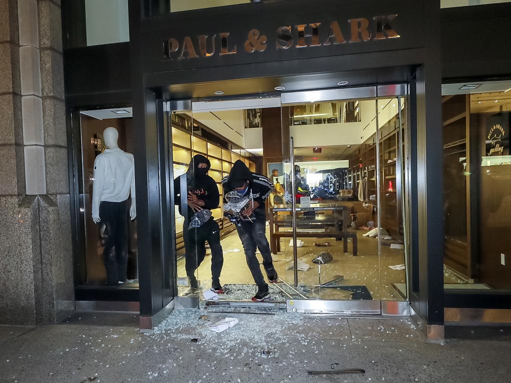 People loot a business along Madison Avenue in mid-town Manhattan. Picture: Justin Lane