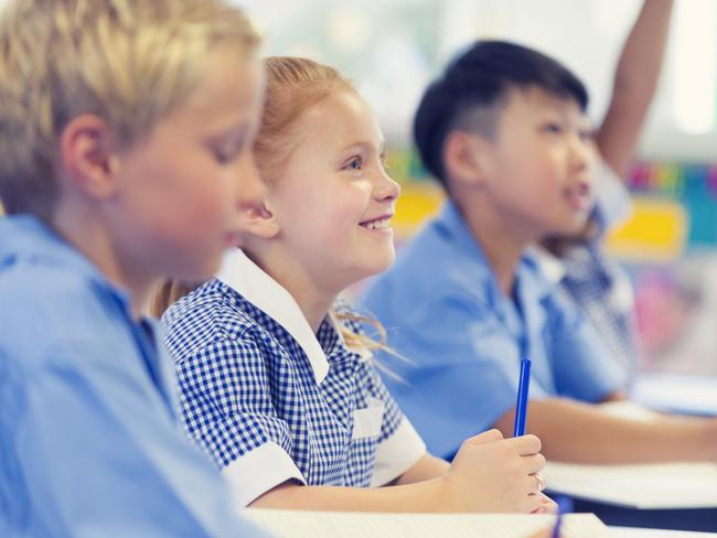 Generic photo of happy students in their classroom wearing their school uniform