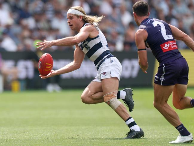 GEELONG, AUSTRALIA - MARCH 15: Bailey Smith of the Cats runs with the ball under pressure from Jaeger O'Meara of the Dockers during the round one AFL match between Geelong Cats and Fremantle Dockers at GMHBA Stadium, on March 15, 2025, in Geelong, Australia. (Photo by Daniel Pockett/Getty Images)