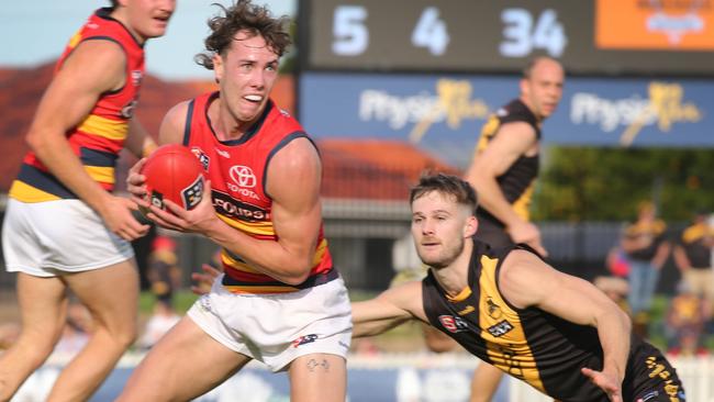 Crow Tyler Brown breaks clear of Tiger Jonty Scharenberg at Glenelg Oval. Picture: Dean Martin