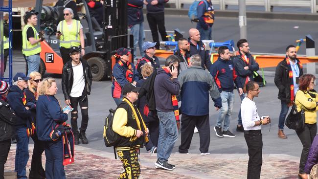 Football fans watch as Police bomb squad inspect the car and package on Flinders Street in Melbourne. Picture: Tony Gough