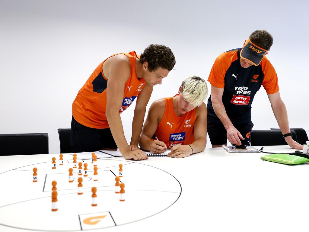 Hamilton takes notes from Josh Kelly and Ben Hart during a pre-season session in 2023.