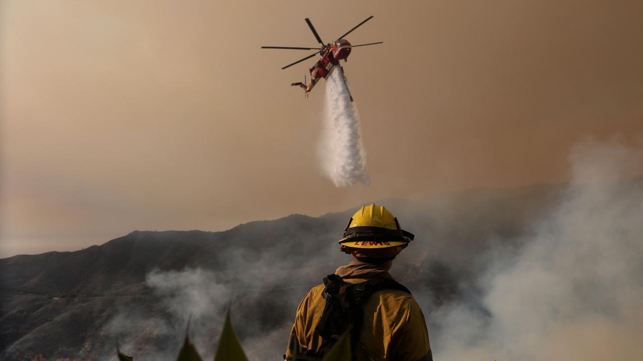 A firefighting helicopter drops water on the Palisades Fire. Picture: Justin Sullivan/Getty Images/AFP