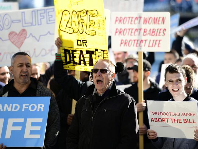 Protesters hold placards at an anti-abortion rally at the International Convention Centre on Saturday. Picture: Picture: AAP