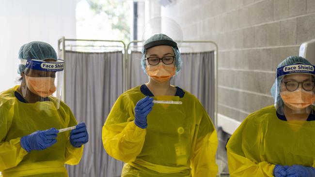 MANLY DAILY. Northern Beaches Hospital Covid 19 clinic photographed today 18th August 2020. Nurses, Joisy Kavalamp, Amanda Fallon and Jade Doliente in the hot zone waiting to pass off tests for processing. Image Matthew Vasilescu