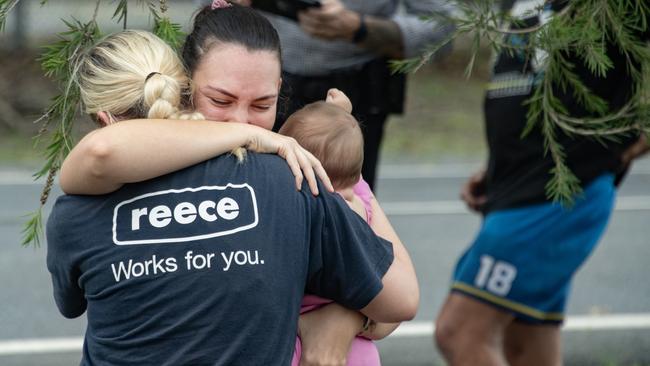 Evacuees reunite with family members at the Barron River bridge north of Cairns. Picture: NCA NewsWire / Brian Cassey