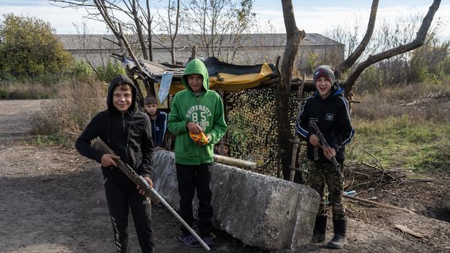 Boys hold toy rifles as they pause while playing by the roadside in the Kharkiv area on Wednesday. Picture: Getty Images