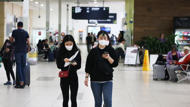 Tourists wearing masks at Gold Coast Airport as the Coronavirus epidemic causes havoc with peoples travel plans. Picture Glenn Hampson