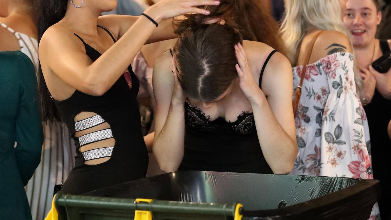 A friend holds woman's hair in Brunswick Street Mall after a having a bit too much to drink during New Year's Eve celebrations in Brisbane. Picture: Liam Kidston.