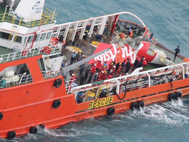 The tail of the downed QZ8501 plane is hoisted from under water.