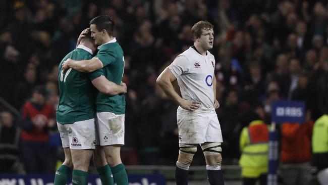Ireland’s Cian Healy and Johnny Sexton embrace as England’s Joe Launchbury reacts.
