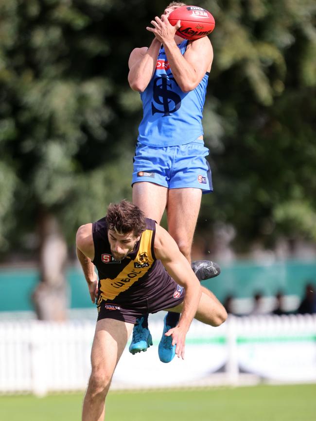 Sturt’s Oliver Grivell leaps high over Glenelg captain Max Proud at Unley Oval on Saturday. Picture: Cory Sutton