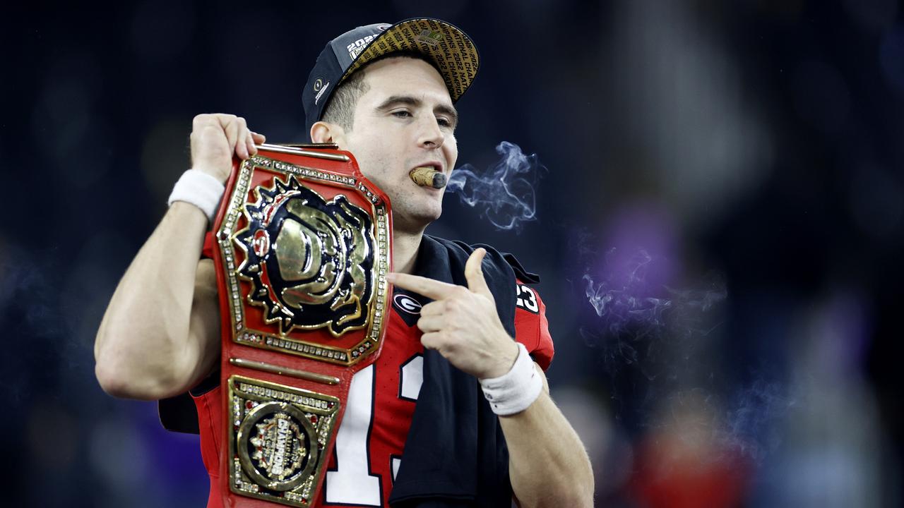 INGLEWOOD, CALIFORNIA - JANUARY 09: Stetson Bennett #13 of the Georgia Bulldogs celebrates with teammates and a cigar after defeating the TCU Horned Frogs in the College Football Playoff National Championship game at SoFi Stadium on January 09, 2023 in Inglewood, California. Georgia defeated TCU 65-7. (Photo by Steph Chambers/Getty Images)