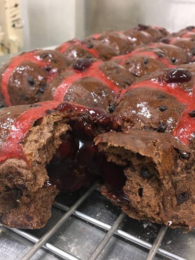 The cherry ripe hot cross buns are filled with cherry sauce.