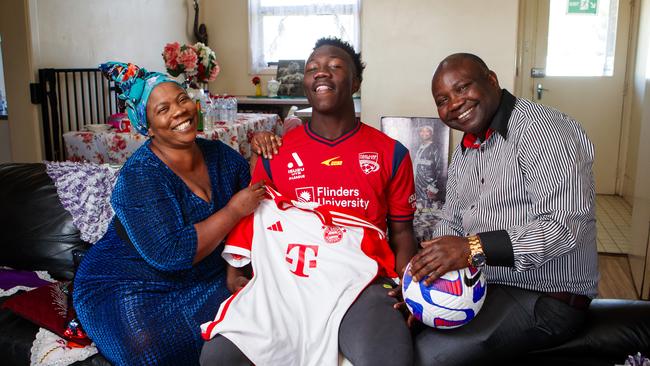 Adelaide United star player Nestory Irankunda with his mother Dafroza Siyajali and father Gideon Rurandagaye at home in Adelaide. Nestory will sign with FC Bayern Munich next week. Picture: Matt Turner