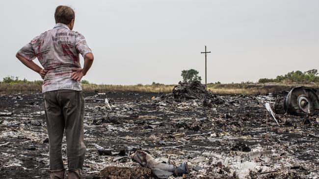 A man looks at debris from an Malaysia Airlines plane crash