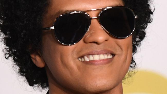 TOPSHOT - Singer Bruno Mars poses in the press room with his Grammy trophies during the 60th Annual Grammy Awards on January 28, 2018, in New York. / AFP PHOTO / Don EMMERT