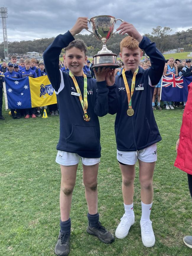 Victorian captain Darby Hoare (right) and vice captain Kobe Treeby lift the national trophy.