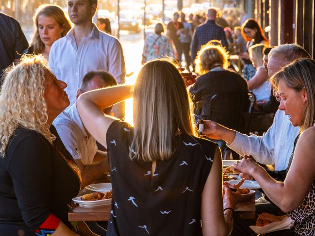 Newtown, Sydney, NSW - 27 10 2018: A group of friends eating and chatting al fresco in a late afternoon in Newtown, Sydney