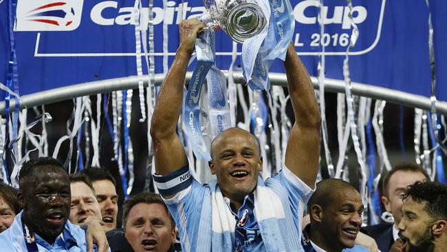 Vincent Kompany raises the trophy after winning the English League Cup final.