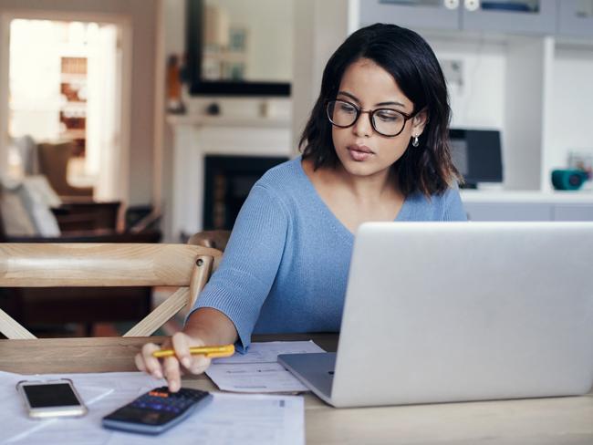 OZ_BIZ_SUMMERFINANCETIPS -  Shot of a young woman using a laptop and calculator while working from home