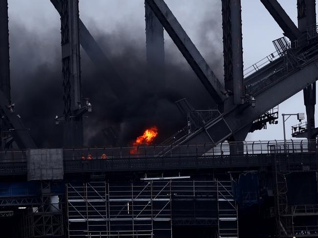 A car burst into flames when it crashed with another vehicle just before 7am on Monday. The Sydney Harbour Bridge was closed to traffic in both directions. Photo: Brendon Thorne/Getty Images