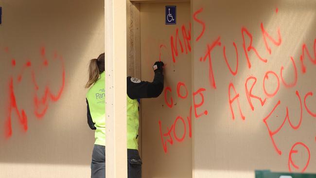 Workers remove the offensive graffiti. Picture: Matrix Media Group