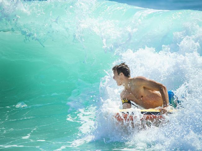 A bodyboarder makes the most of early surf conditions at Coolum as strong winds and rain hits the Sunshine Coast for Boxing Day. Picture: Lachie Millard