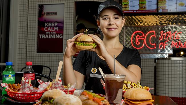 You might think vegan food is always healthy, but even vegans crave something a bit naughty. Staff member Priya Mann digs into a burger. Picture: Jerad Williams