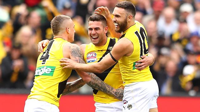 Jack Graham celebrates a goal with Dustin Martin and Shane Edwards.