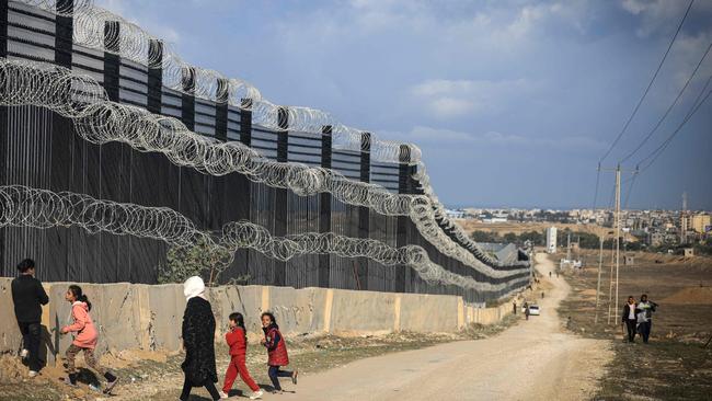 Displaced Palestinians walk along the Philadelphi Corridor, a narrow buffer zone along the Gaza Strip's border with Egypt. Picture: AFP.