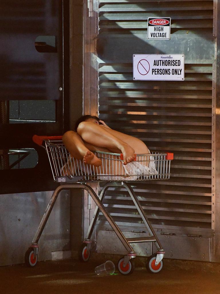 A young lady takes a break in a shopping cart behind Monsoons in the early hours of New Year's day